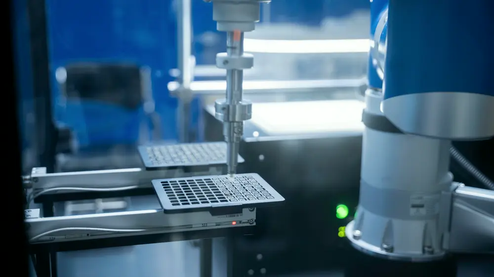Robotic arm handling a sample plate in an automated lab