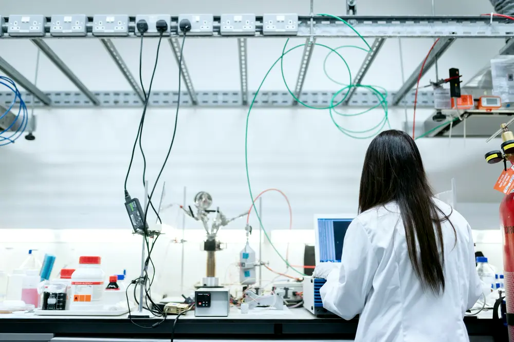 Scientist at a chemistry lab bench with tubing and glassware